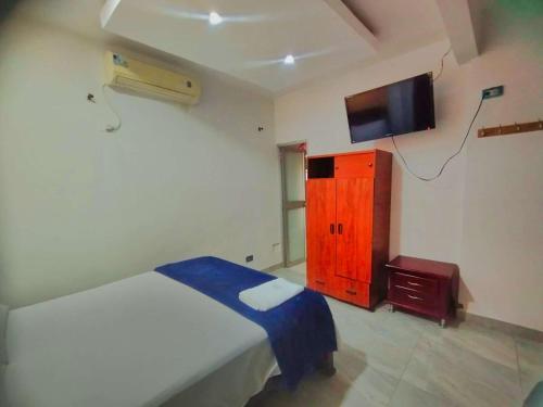 a bedroom with a bed and a tv on the wall at Hotel El Sol Inn in Aguachica