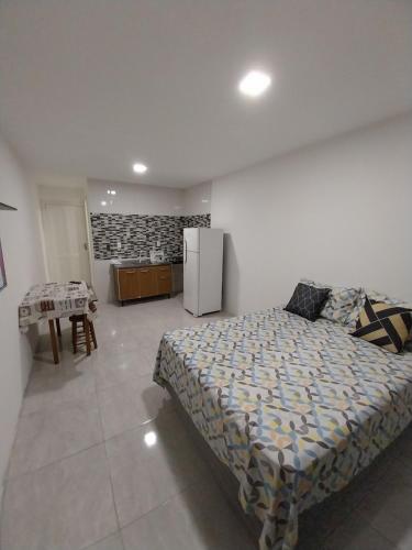 a bedroom with a bed and a table and a refrigerator at Pousada Vista da Lagoa in Florianópolis