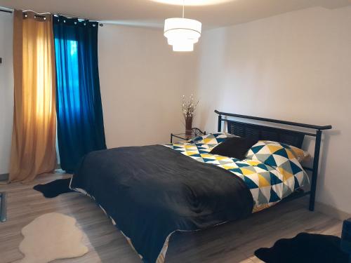 a bedroom with a bed and blue curtains at Vacances entre plage et montagnes in Baigts-de-Béarn