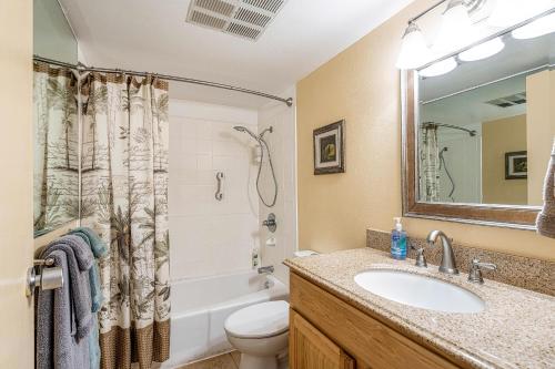 a bathroom with a sink and a toilet and a mirror at Maalaea Kai 311 - Direct Ocean Front, Split AC in Wailuku
