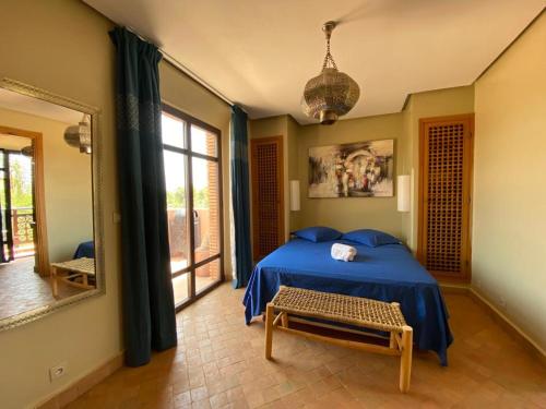 a bedroom with a blue bed and a mirror at Villa rouge avec piscine et golf in Marrakech