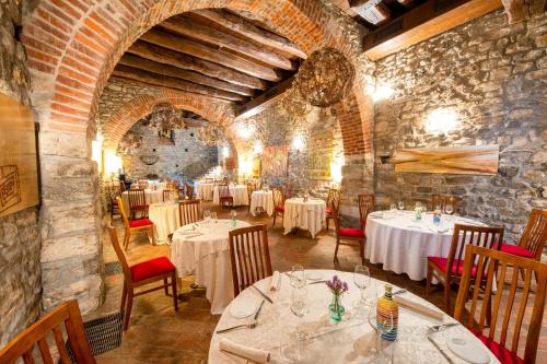 un restaurante con mesas y sillas en una pared de piedra en Relais & Spa Castello di Casiglio, en Erba