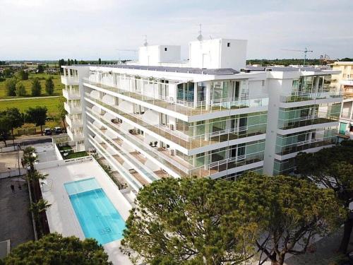 a large white building with a pool in front of it at Palm beach appartment 80 mt dal mare e comodo per Venezia in Lido di Jesolo