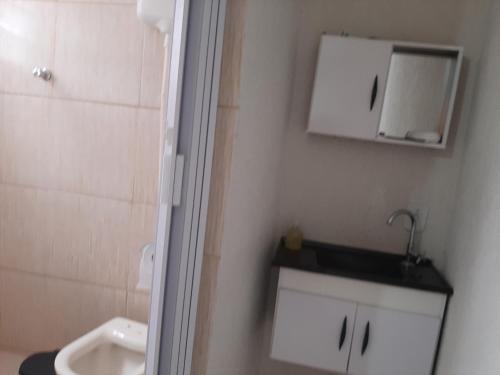 uma casa de banho com um lavatório, um WC e um espelho. em Casa compacta em São Caetano do Sul