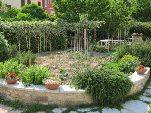 a garden with potted plants on a stone wall at La Residence da Caterina in Vittorio Veneto