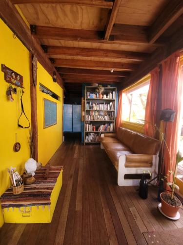 a living room with a couch and a book shelf at Casa Encantada Guest House in La Aguada