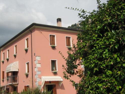 a pink building with flowers on the windows at La Residence da Caterina in Vittorio Veneto