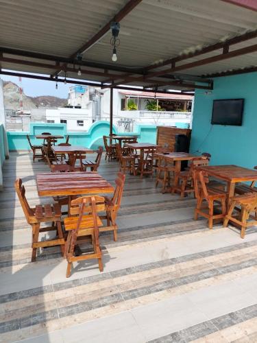 a group of wooden tables and chairs on a patio at Hotel Las Vegas by CMS hotels in Santa Marta