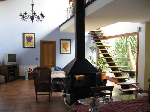 ein Wohnzimmer mit einer Treppe und einem Kamin in der Unterkunft Casa Rural Planet in Bolulla