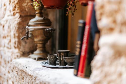 a group of cups sitting on a stone wall at Hebi house in ‘Akko