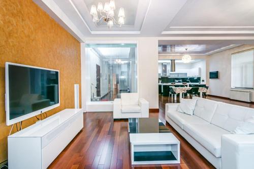 a living room with a white couch and a tv at Vip Apartment Zanzibar in Baku
