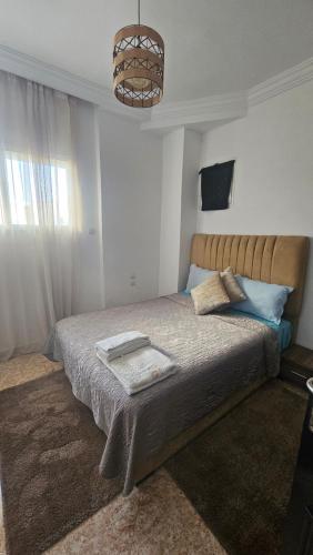 een slaapkamer met een bed en een kroonluchter bij Amina House in Essaouira