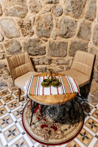 two chairs and a table in a room at Hebi house in ‘Akko