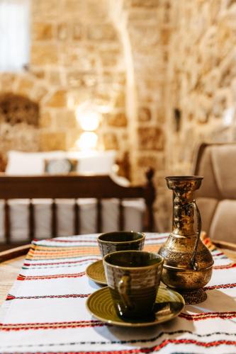 a table with two cups and a vase on it at Hebi house in ‘Akko