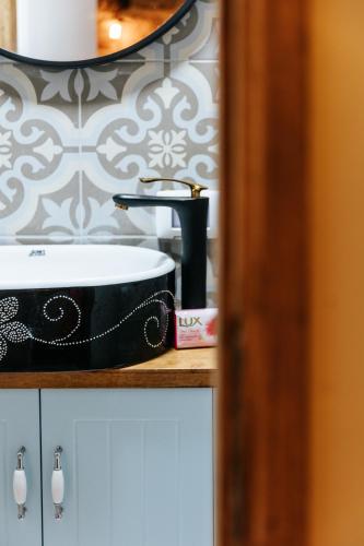 a bathroom sink with a black and white wallpaper at Hebi house in ‘Akko