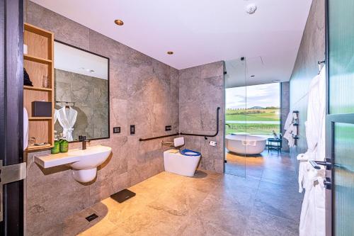 a bathroom with a sink and a tub and a toilet at Re’em Yarra Valley in Gruyere