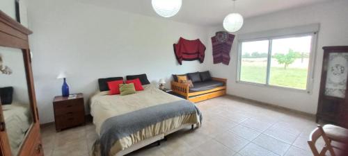 a bedroom with a bed and a window at Hermosa casa de campo y bosques in Toay