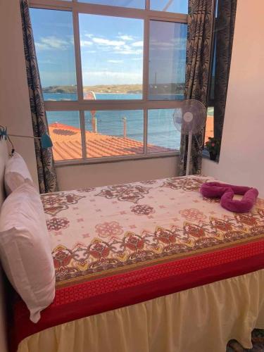 a bed with a window with a view of the ocean at Sea View Big Lanche in Praia Baixo