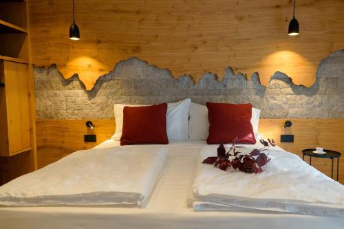 a bedroom with a large white bed with red pillows at Chalet Larix Andalo Deluxe Apartments in Andalo