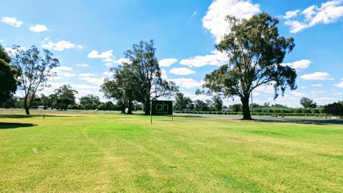 een park met een bord in het midden van een veld bij Australian Homestead Motor Lodge in Wagga Wagga