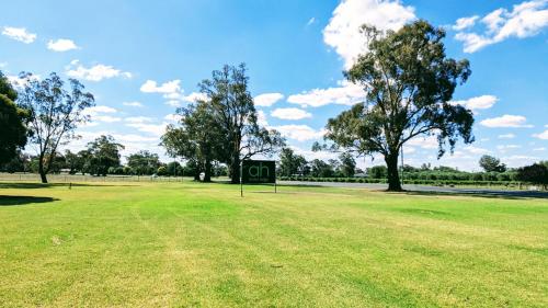 a park with a sign in the middle of a field at Australian Homestead Motor Lodge in Wagga Wagga