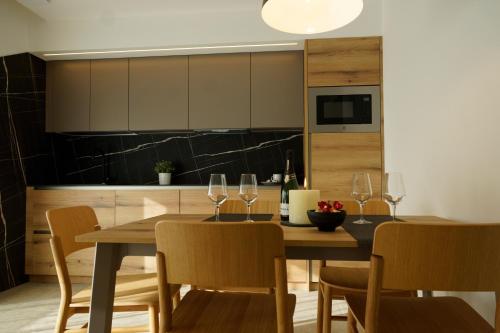 a kitchen with a wooden table with wine glasses at Chalet Larix Andalo Deluxe Apartments in Andalo