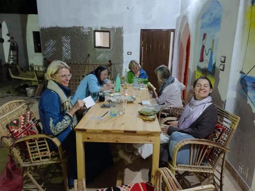 un gruppo di donne sedute intorno a un tavolo di legno di ABU Guest House a Aswan