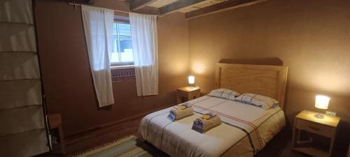 een slaapkamer met een bed, een raam en 2 lampen bij Muyakuelap Eco house & Ecolife in Nuevo Tingo