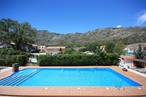a swimming pool with a mountain in the background at Hotel Rural Montaña de Cazorla in Arroyo Frio