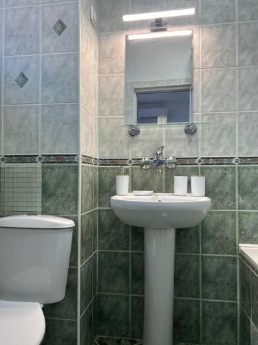 a bathroom with a sink and a toilet and a mirror at Pirostka Vintage Room in Sofia