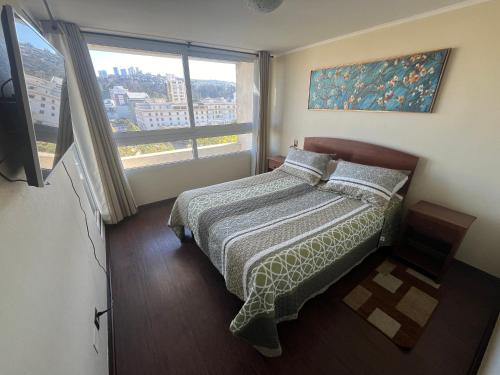 a bedroom with a bed and a large window at Viña del Mar - Parque Marina in Viña del Mar