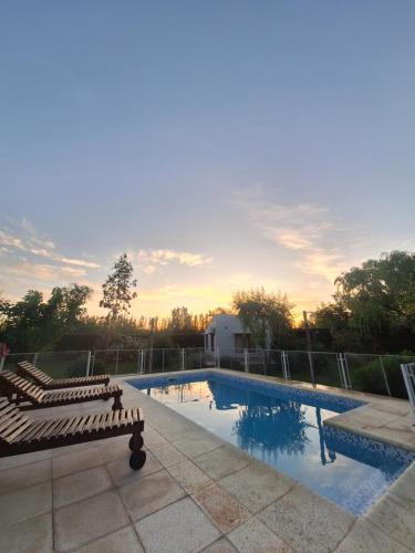 ein Pool mit zwei Liegestühlen daneben in der Unterkunft Los Niyus in San Rafael