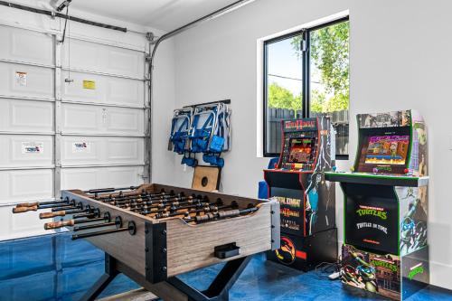 um quarto com duas máquinas de jogos de vídeo e uma mesa em Heated Saltwater Pool, Arcades, Golf - 5min to Las Olas Boulevard em Fort Lauderdale