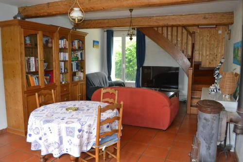 uma sala de estar com um sofá vermelho e uma mesa em Maison familiale Sud Drôme-Ardèche em Châteauneuf-du-Rhône