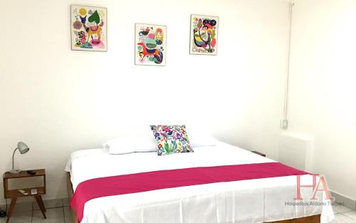 1 dormitorio con 1 cama con 3 cuadros en la pared en Hospedaje Aldana Apartamento AURA Centro Histórico, en Tuxpan de Rodríguez Cano