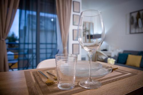 a wine glass sitting on a table with a plate and a glass at Le Beverley Studio in Blain