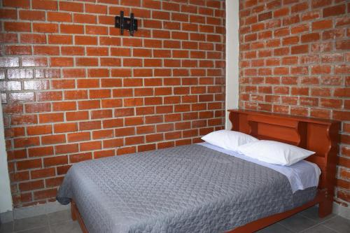 a brick wall with a bed in a room at El Valle Lunahuaná in Lunahuaná