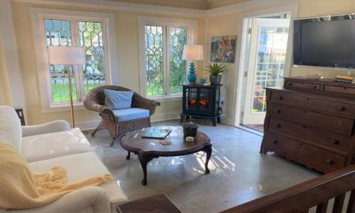 uma sala de estar com uma televisão e uma mesa de centro em Rosemont B&B Cottages em Little Rock