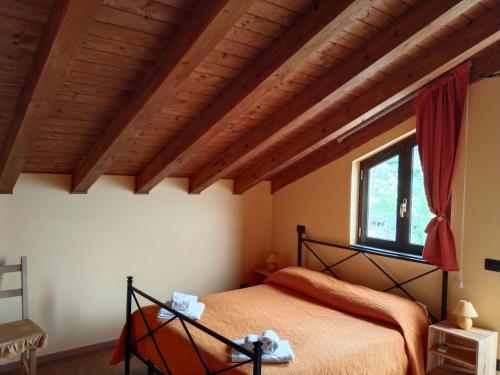 una camera con letto in una stanza con soffitti in legno di Aurora dell'Etna a Zafferana Etnea