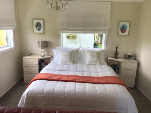 um quarto com uma cama grande e um cobertor vermelho e branco em Mohaonui Farmstay em Otorohanga