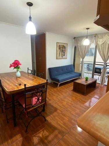 a living room with a blue couch and a table at Departamento Vistamar in Arica
