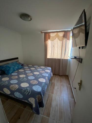 a small bedroom with a bed and a window at Departamento Vistamar in Arica