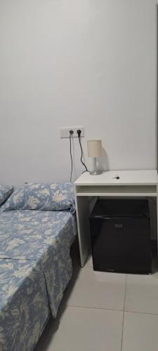 1 dormitorio con 1 cama y escritorio con lámpara en La Marina, en Alicante