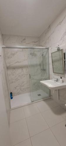 baño blanco con ducha y lavamanos en La Marina, en Alicante