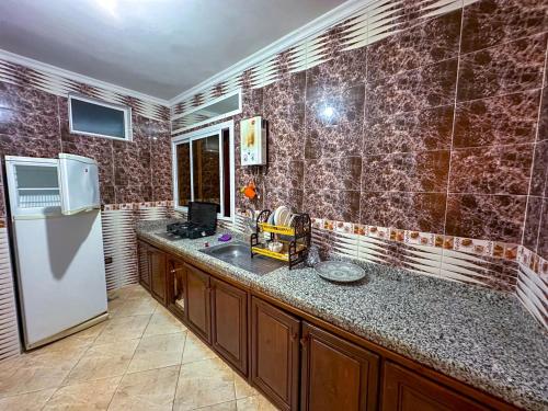 a kitchen with a refrigerator and a counter top at Appartement el hichou 1 in Ksar es Sghir