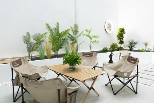stół i krzesła w pokoju z roślinami w obiekcie Hetao B&B w mieście Tongxiang