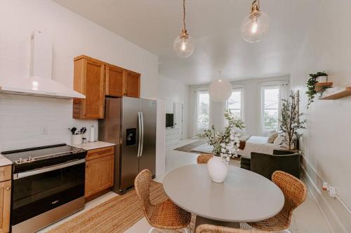 a kitchen with a white table and a white counter top at East Main Lofts - Coastal 201 in Madison