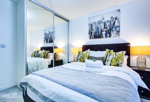 a bedroom with a large bed and a large mirror at Luxee Apartment by Excel in London