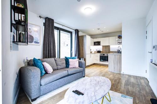 a living room with a couch and a kitchen at Luxee Apartment by Excel in London