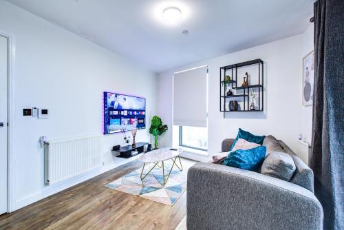 a living room with a couch and a tv at Luxee Apartment by Excel in London
